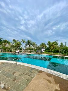 uma grande piscina com palmeiras ao fundo em SEA LA VIE SWEET @ NAUTICA RESORT em Porto Dickson