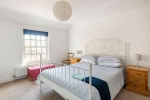 a bedroom with a white bed and a window at Kingfisher Cottage - Woodbridge in Woodbridge