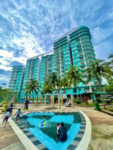 a group of people playing in a swimming pool in front of a building at SEA LA VIE SWEET @ NAUTICA RESORT in Port Dickson
