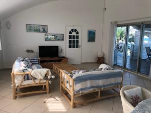 a living room with two beds and a flat screen tv at vert lagon in Saint-Pierre