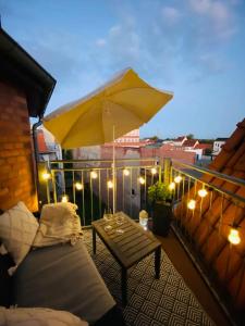 eine Terrasse mit einem Tisch und einem Sonnenschirm auf dem Balkon in der Unterkunft Home Cinema - Balcony - Wi-Fi & Streams in Magdeburg