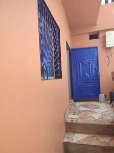 un couloir avec une porte bleue et un escalier dans l'établissement Dar Si Brahim, cozy house in Hyoute chair, à Oualidia