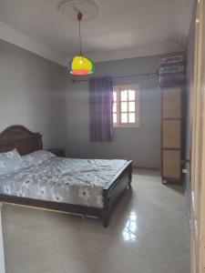 - une chambre avec un lit dans une pièce dotée d'une fenêtre dans l'établissement Dar Si Brahim, cozy house in Hyoute chair, à Oualidia