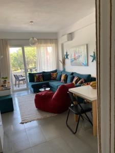 sala de estar con sofá azul y mesa en Hanah Apartment - Gjiri Lalzit Lura 3, en Mullini i Danit