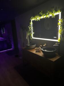 un bagno con due lavandini e una finestra con luci di Homesuiteandspa a Flers-en-Escribeus