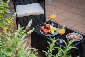 a table with two glasses of wine and a plate of fruit at White Swan Boutique Apartments in Prague