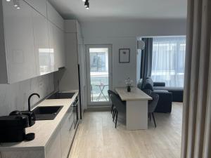 a kitchen and living room with a table and a couch at L&C Platinum Property in Năvodari
