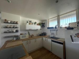 a kitchen with white cabinets and a white refrigerator at Joli duplex de 75m2 à 10mn à pieds de la plage in Le Lavandou +6 photos