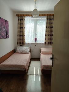 two beds in a room with a window at Apartman Veronika v rodinnom dome in Snina