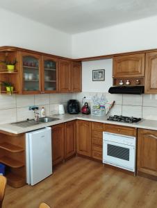 a kitchen with wooden cabinets and a white stove top oven at Apartman Veronika v rodinnom dome in Snina