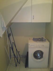 une laveuse et une sécheuse dans une petite pièce dans l'établissement EK Studio Appartement, à Saint Etienne