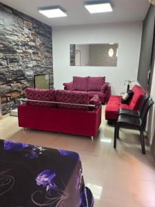 - un salon avec un canapé rouge et une chaise dans l'établissement Casona de flores ll, à Fuensalida