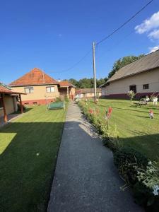 a walkway in a yard next to a house at Casa Izvorul Rece in Hobiţa