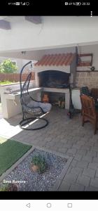 a patio with a chair and a table and a fireplace at Tea in Povljana