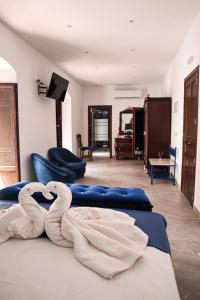 two towel swans sitting on a bed in a room at CASA DE LA SEÑORA in Palma del Río