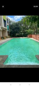 una piscina de agua azul turquesa frente a un edificio en Tranquil home near vagator beach, en Anjuna