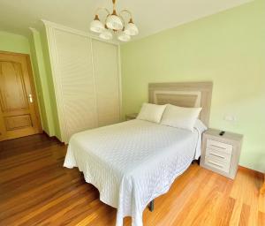 een slaapkamer met een wit bed en een nachtkastje bij Apartamento Bellavista in Portonovo