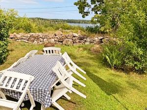 a picnic table with two chairs and a stone wall at 5 person holiday home in LOFTAHAMMAR in Loftahammar
