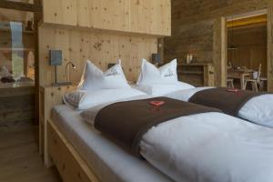 eine Reihe von drei Betten in einem Zimmer in der Unterkunft Chalet Wiesenglück in Gsieser Tal