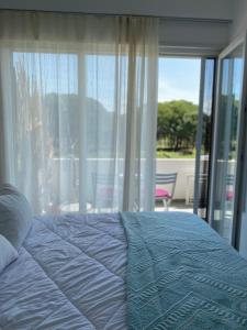 a bedroom with a bed and a large window at Hanah Apartment - Gjiri Lalzit Lura 3 in Mullini i Danit