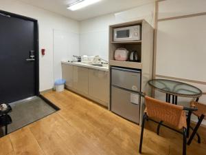 a small kitchen with a table and a microwave at Cordelia Resort in Seogwipo