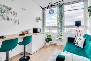 ein Wohnzimmer mit einem grünen Sofa und einer Küche in der Unterkunft Serce Opola Katowicka 39 in Oppeln