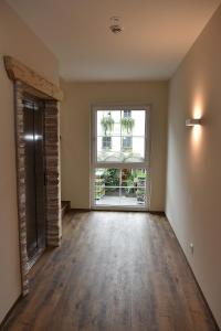 an empty room with a large window and wooden floors at Gasthof Lebzelter in Strasswalchen