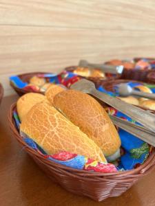 um cesto de pão com pinças numa mesa em Pousada Pangea Tropical em Arraial d'Ajuda