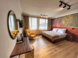 a bedroom with a bed and a table and a mirror at Oji Hotel in Alanya