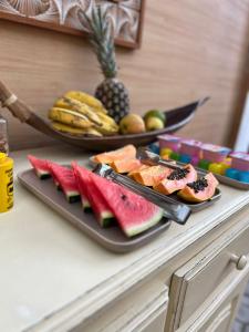 una mesa cubierta con dos platos de sandía y fruta en Pousada Pangea Tropical en Arraial d'Ajuda