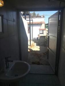 baño con lavabo y puerta a un patio en Summer Sea Family House+Yard, en Sozopoli
