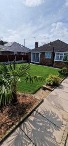 una casa con un patio con una palmera en Linksway House en Birkenhead