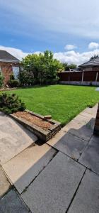 a backyard with a lawn and a garden withgrass at Linksway House in Birkenhead