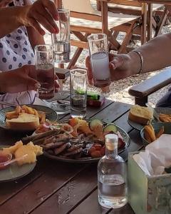 una mesa con platos de comida y vasos de agua en Summer Sea Family House+Yard, en Sozopoli