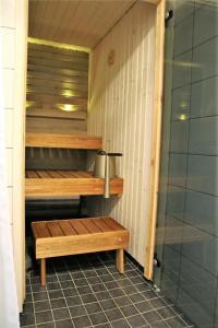 a sauna with wooden shelves and a shower at Saunallinen kaksio, asunto Kolin Kolo in Kolinkylä