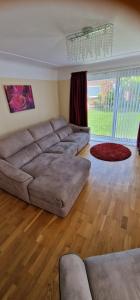 a living room with a large couch and a large window at Linksway House in Birkenhead