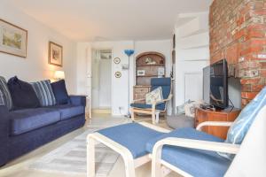 een woonkamer met een bank en een tv bij Mulberry Cottage in Cowes