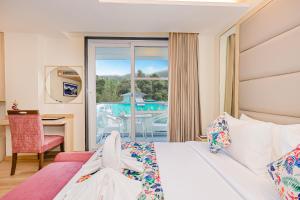 a bedroom with a bed and a desk and a window at Regenta Inn Luxinna Heights Mcleodganj in Dharamshala