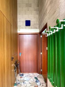 a hallway with a wooden door and green accents at Industriële WOW! Privé studio-39m2-Eigen ingang in Amsterdam