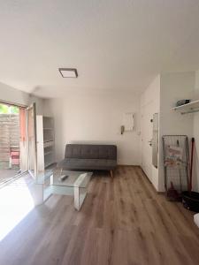 ein Wohnzimmer mit einem Sofa und einem Tisch in der Unterkunft Les jacinthes in Marseille