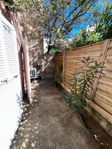 a backyard with a wooden fence and a bench at Les jacinthes in Marseille