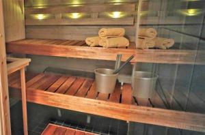 a sauna with towels and two cups on a shelf at Saunallinen kaksio, asunto Kolin Kolo in Kolinkylä