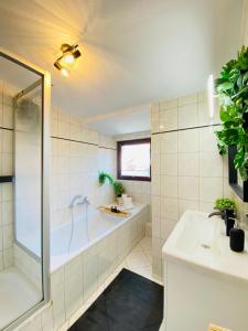 ein Badezimmer mit einer Badewanne und einem Waschbecken in der Unterkunft Home Cinema - Balcony - Wi-Fi & Streams in Magdeburg
