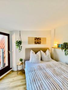 ein Schlafzimmer mit einem Bett mit gestreifter Bettwäsche und einem Fenster in der Unterkunft Home Cinema - Balcony - Wi-Fi & Streams in Magdeburg