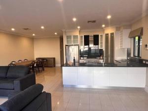 a kitchen and living room with a couch and a table at Executive Villa Close To CBD with Spa in Prospect