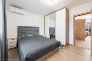 1 dormitorio con cama y espejo grande en K - Residence 16, en Varna
