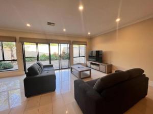 a living room with two couches and a television at Executive Villa Close To CBD with Spa in Prospect
