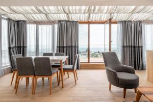 comedor con mesa, sillas y ventanas en K - Residence 16, en Varna