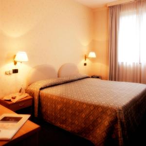 a hotel room with a bed and a window at Hotel Ristorante La Lanterna in Castelnuovo di Garfagnana