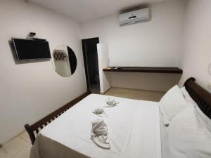 a room with a bed with a white table and a mirror at Pousada Água de Fuego in Maragogi